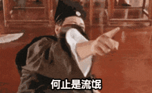 a man in a costume is pointing at something with chinese writing on it