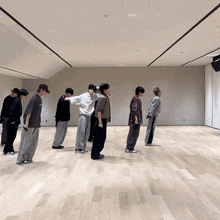 a group of young men are standing in a row on a wood floor