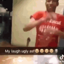 a man in a red shirt is making a heart shape with his hands and says `` my laugh ugly ass '' .