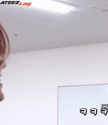 a close up of a person 's face in a room with the words ateez log written on the ceiling