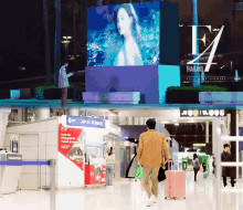 a man stands in front of a large screen that says thailand on it