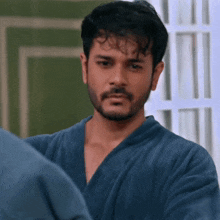 a man with a beard is wearing a bathrobe