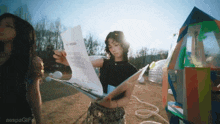 a woman is holding a piece of paper with the word aespa written on the bottom