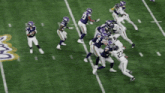 a football player with the number 27 on his jersey is being tackled