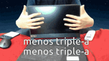 a person is holding a laptop with the words " menos triple-a menos triple-a " on the bottom