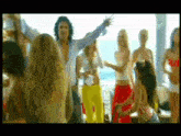 a group of people are dancing in front of a window with the ocean in the background