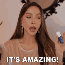 a woman says it 's amazing while holding a blue bottle