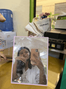 a woman taking a selfie in front of a mirror that says " gentlewoman " on it