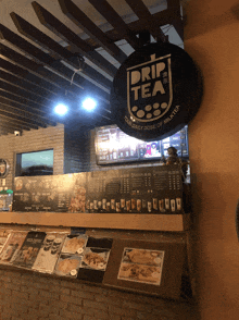 a drip tea sign hangs above a counter