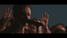 a man sings into a microphone in front of a crowd of people