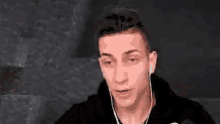 a young man wearing earphones is making a funny face .
