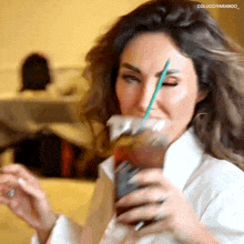 a woman drinking from a plastic cup with a green straw and the words colucciyarango on the bottom