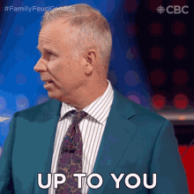 a man wearing a suit and tie says up to you