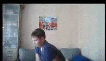 a boy is sitting on a couch in front of a painting of london
