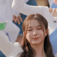 a close up of a woman 's face with her eyes closed and her arms in the air