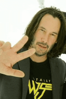 a man with long hair is wearing a black shirt that says totally w5