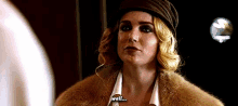 a woman wearing a fur coat and hat says " well "