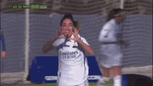 a soccer player wearing an emirates fly better jersey celebrates