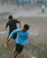 a blurry picture of a man in a blue shirt playing soccer