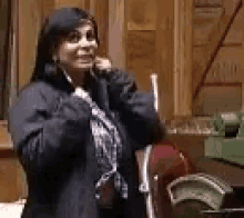 a woman is standing in a room talking on a phone .
