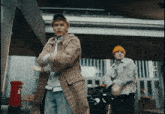 a man in a plaid coat and a yellow hat is dancing