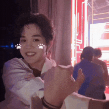 a young man giving a thumbs up with a paw print on his face