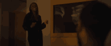 a woman in a black dress is standing next to a man in a dark room .