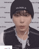 a young man wearing a black beanie with the word mumble embroidered on it