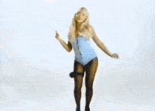 a woman in a blue leotard and black tights is dancing .