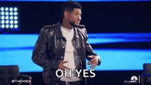 a man in a leather jacket says " oh yes " on a stage