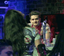 a man and a woman are sitting at a bar looking at each other