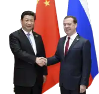 a man in a suit shakes hands with a man in a tie