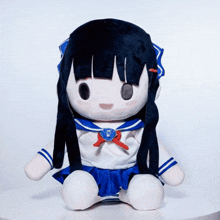 a stuffed doll with long black hair is wearing a sailor outfit with the letter c on it