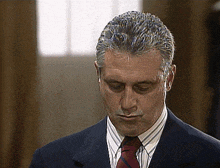 a man in a suit and tie with his eyes closed