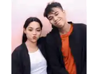 a man and a woman are posing for a picture with the woman blowing a kiss