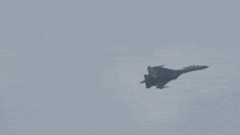 a fighter jet flying through a cloudy sky