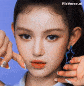 a close up of a woman 's face with a blue star shaped earring .
