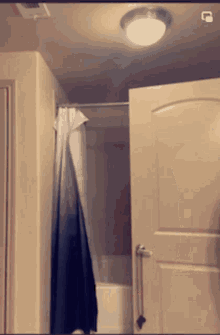 a bathroom with a shower curtain hanging from the ceiling