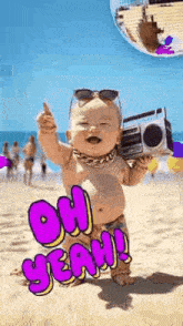 a baby is holding a boombox on the beach .