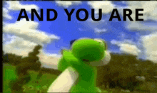 a green and white stuffed animal is standing in a field with the words `` and you are '' written on it .
