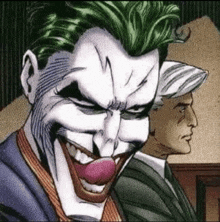 a close up of the joker 's face with a clown nose and tongue sticking out .