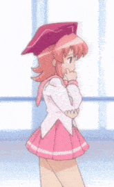 a girl in a pink dress and a pink hat stands in front of a window