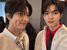 two young men are standing next to each other and one of them is wearing a shirt that says ' a ' on it
