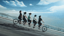 four girls are riding a tandem bicycle on a road