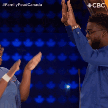 a man and a woman are giving each other a high five while wearing blue shirts that say cbc