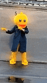 a yellow duck mascot is standing in front of a container with the number 5 on it