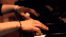 a person playing a piano with a blue wristband