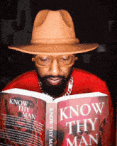 a man in a hat is reading a book titled know thy man