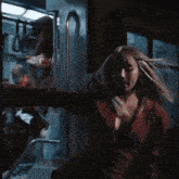 a woman in a red jacket is standing next to a door
