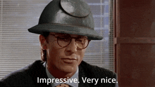 a man wearing glasses and a hard hat says " impressive very nice "